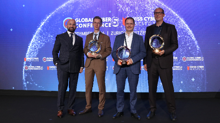 Die ersten Awards des Tages (v.l.): Samir Aliyev, CEO und Gründer des Swiss Cyber Institute, Matthias Gsteiger, Lead Course Instructor beim Swiss Cyber Institute, Tom Schmidt, Partner und Leiter Cybersecurity beim EY Schweiz, und Florian Schütz, Direktor des BACS. (Source: Netzmedien)